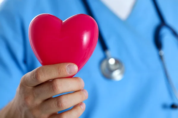 Manlig medicin läkare bär blå uniform håll i handen röd leksak h — Stockfoto