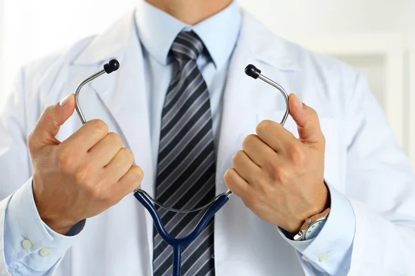 Male medicine doctor hands hold and put on stethoscope — Stock Photo, Image