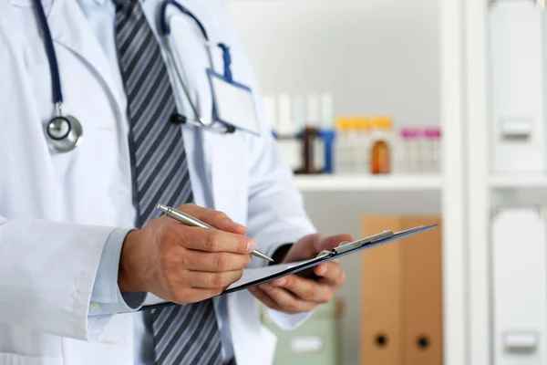 Médico masculino mano sosteniendo pluma de plata escritura —  Fotos de Stock