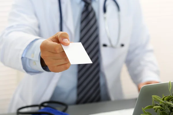 Männlicher Arzt hält weiße Blanko-Visitenkarte in der Hand — Stockfoto