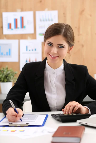 Schöne Geschäftsfrau sitzt am Arbeitsplatz in Büroarbeit mit Pap — Stockfoto