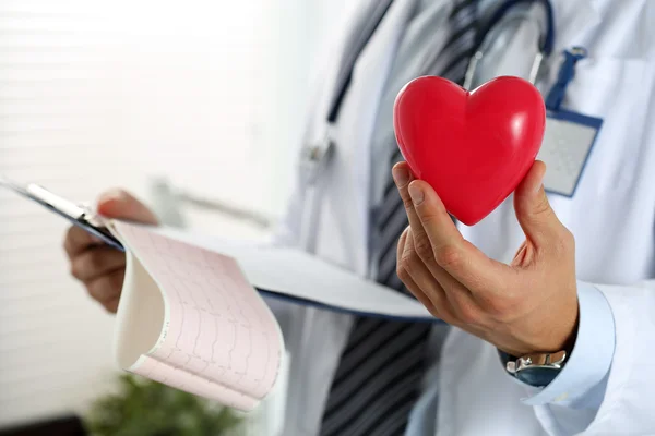 Mannelijke geneeskunde arts handen met rode speelgoed hart — Stockfoto