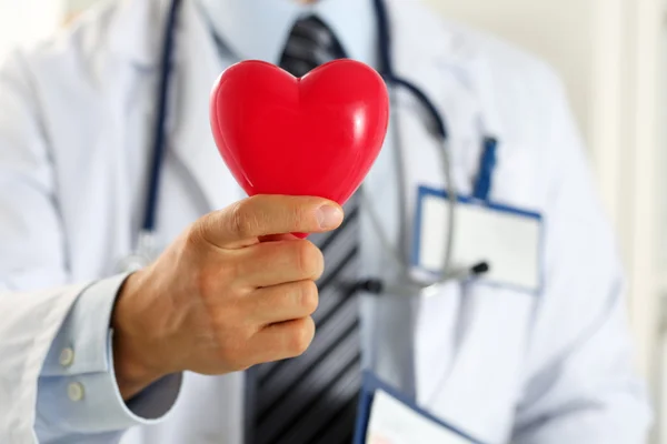 Kırmızı oyuncak kalp holding erkek tıp doktor eller — Stok fotoğraf