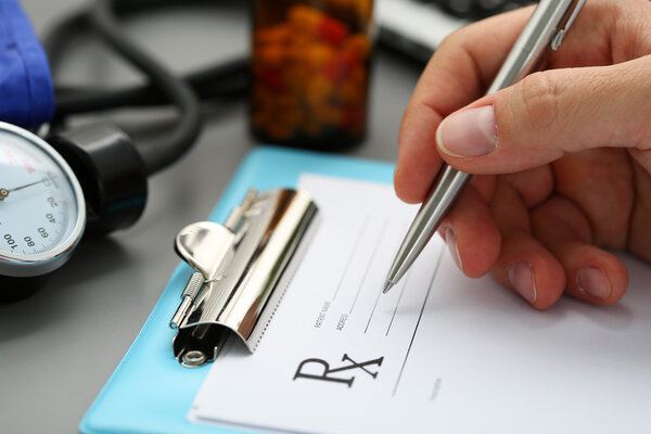 Male medicine doctor hand write prescription to patient