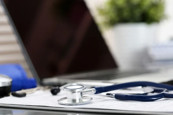 Stethoscope head lying on medical form on clipboard pad — Stock Photo, Image