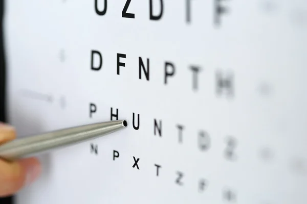 Silver ballpoint pen pointing to letter in eyesight check table — Stock Photo, Image