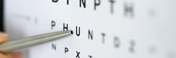 Silver ballpoint pen pointing to letter in eyesight check table — Stock Photo, Image