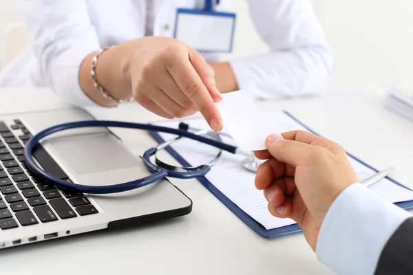 Female physician hand hold and give calling card — Stock Photo, Image