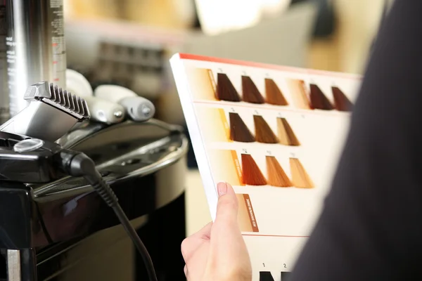 Cabeleireiro visitante salão segurar na mão livro de amostras de cor — Fotografia de Stock