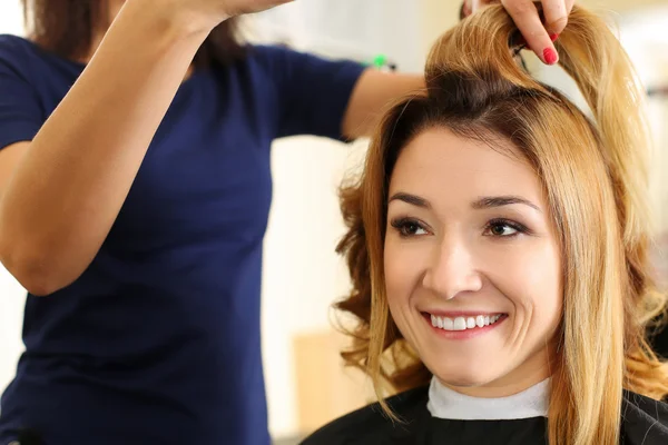 Kvinnlig frisör hålla i hand mellan fingrar lock av hår — Stockfoto