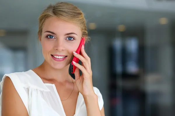 Linda loira sorridente empresária falar vermelho celular — Fotografia de Stock