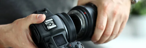 現代のデジタルカメラのプロのレンズに置く男性の手 — ストック写真