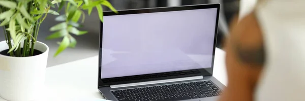 Vrouw zittend aan witte tafel voor laptop — Stockfoto