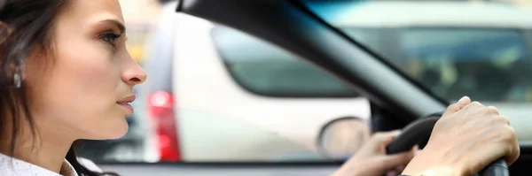 Junge Frau im Hemd sitzt am Steuer eines Autos — Stockfoto