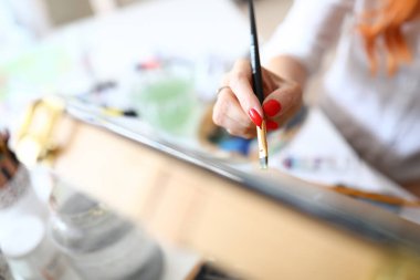 Kırmızı tırnaklı bir kadın eli.