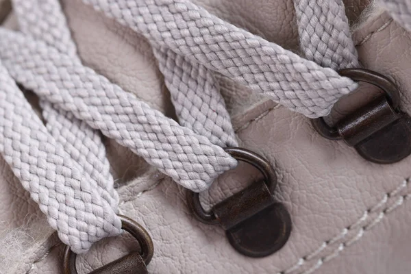 Мереживні шнурки на бежевих чоботях з металевими затискачами — стокове фото