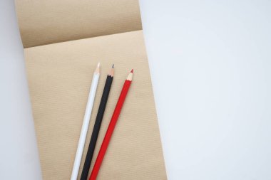 Defterde kırmızı beyaz ve siyah kalemler var..