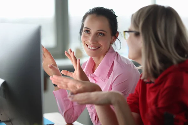 Duas mulheres sorridentes estão sentadas no computador. — Fotografia de Stock