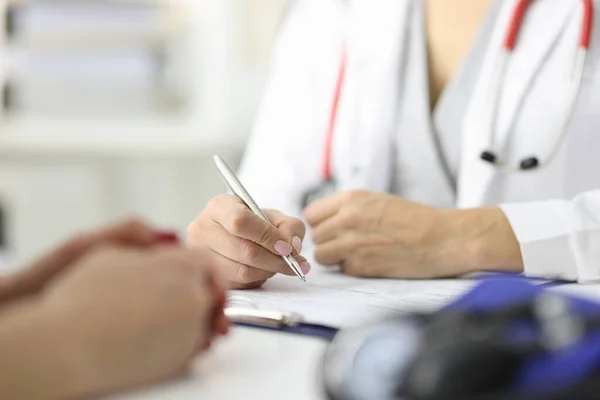 Руки врача и пациента на рабочем столе в медицинском кабинете — стоковое фото