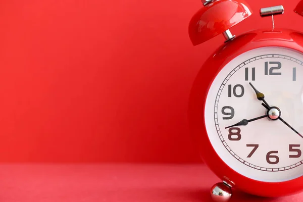빨간 배경 클로즈업에 있는 붉은 알람 시계 — 스톡 사진