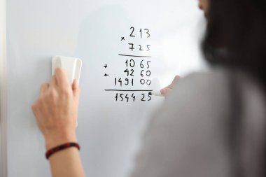 Beyaz panodaki kadın matematik numaraları ekliyor.
