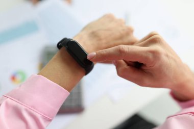 Siyah spor bilekliğinde parmağını gösteren kadın. Yakın plan.