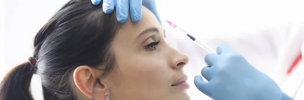 Dokter injecteert de vrouw in voorhoofd closeup — Stockfoto
