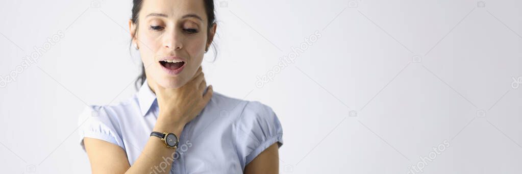 Frustrated woman holds her throat with her hand and coughs