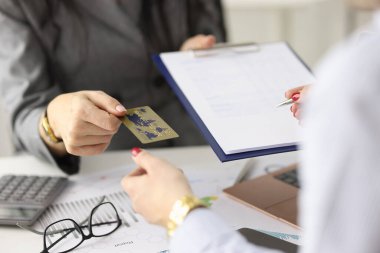 Çalışan, müşteriye imza için plastik banka kartı ve belge verir