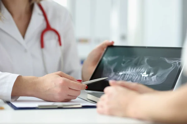 Tandläkare visar patienten tablett med röntgen av tänder i kliniken närbild — Stockfoto