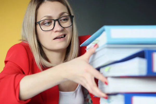 Geschäftsfrau mit Brille hält großen Stapel Ordner mit Dokumenten im Büro — Stockfoto