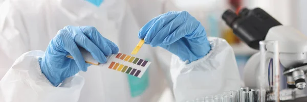 Pesquisador em terno protetor detém reagentes químicos de amostras — Fotografia de Stock