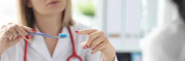 Doktorn visar tandborsten för patienten närbild — Stockfoto