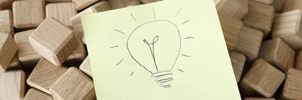 Desenho com lâmpada está em cubos de madeira — Fotografia de Stock