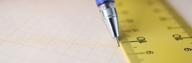 Masada cetvel boyunca çizim çizgisi olan grafik kağıdı var.