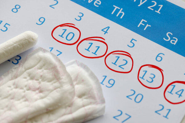 Sanitary pads and tampons are on calendar. Numbers are circled in red pen