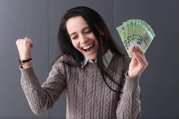 Mujer alegre sostiene euro en su mano —  Fotos de Stock