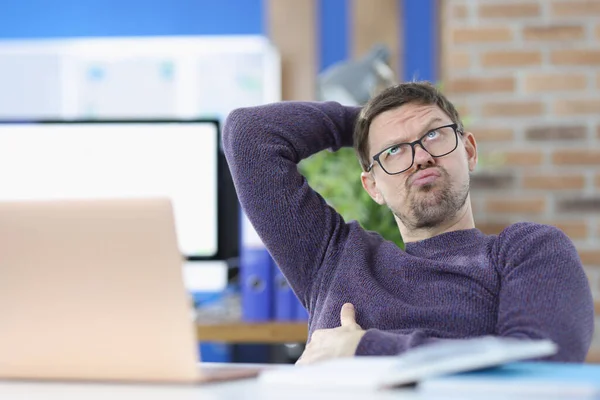 Pensive man sits at work table closeup — Stock Photo, Image