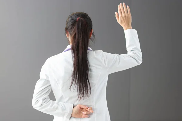 Arzt mit gedrückten Daumen hinter dem Rücken — Stockfoto