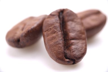 Beyaz arka planda izole edilmiş kavrulmuş kahve çekirdekleri.