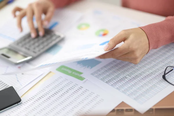 Vrouw met documenten in handen en rekenmachine close-up — Stockfoto