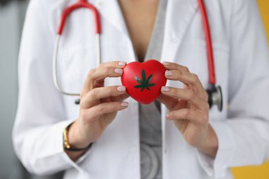 Doktor kalbini marihuana işaretine yakın tutuyor.