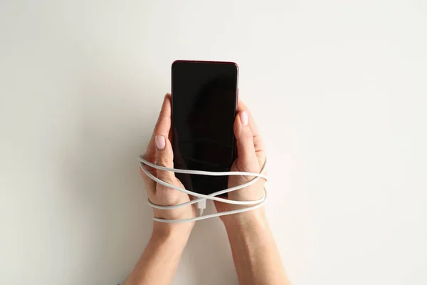 Les mains sont attachées avec du fil et maintenez smartphone — Photo