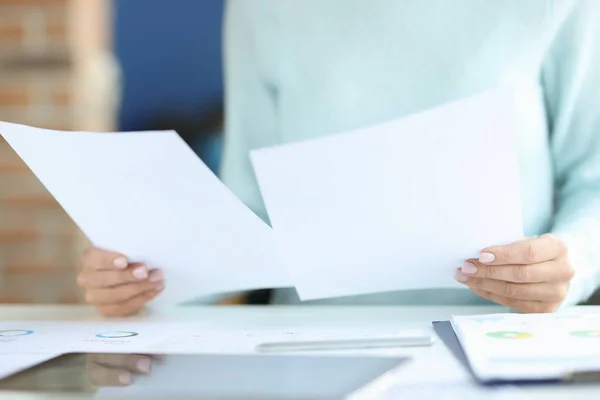 A női kezek dokumentumokat tartanak a munkaasztal felett — Stock Fotó