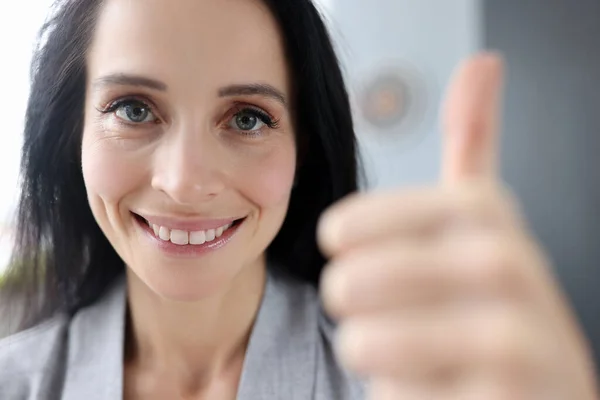 Усміхнена жінка тримає великі пальці крупним планом — стокове фото