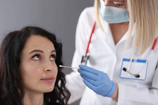 Dermatólogo aplica crema blanca a la cara de los pacientes —  Fotos de Stock