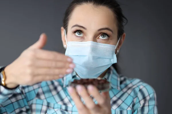 Mujer en máscara médica protectora trata de oler el café —  Fotos de Stock