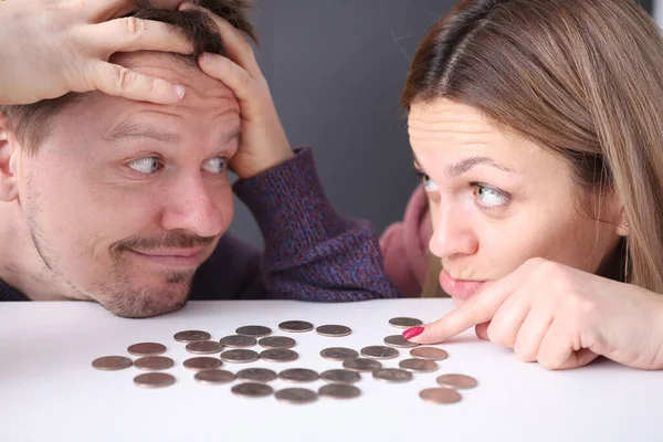 Hombre y mujer miran las monedas en la frustración —  Fotos de Stock