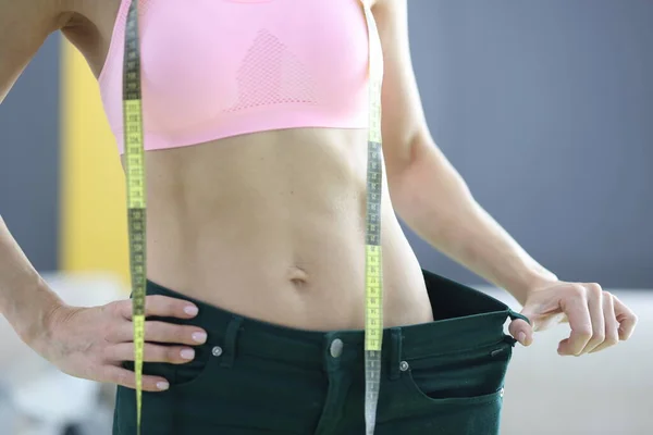 Vrouw meet haar oude jeans en records resultaat van het verliezen van gewicht — Stockfoto