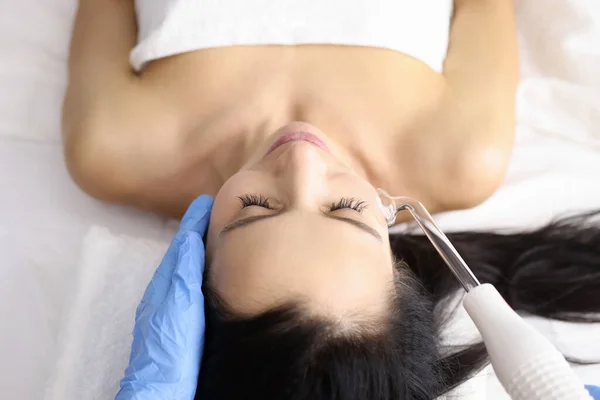 Косметолог дає процедуру Дарсонваль молодій жінці в салоні краси — стокове фото